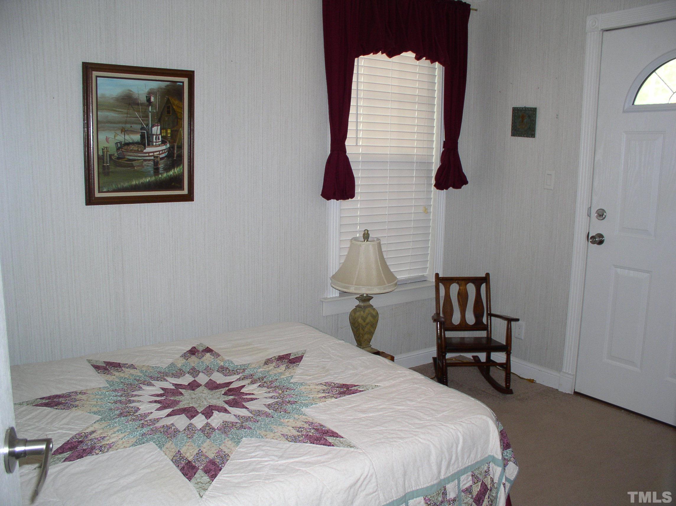 64 Fish Trail Bracey, VA 23919 - Photo 23 of 39 a bedroom with a bed and a lamp on dresser