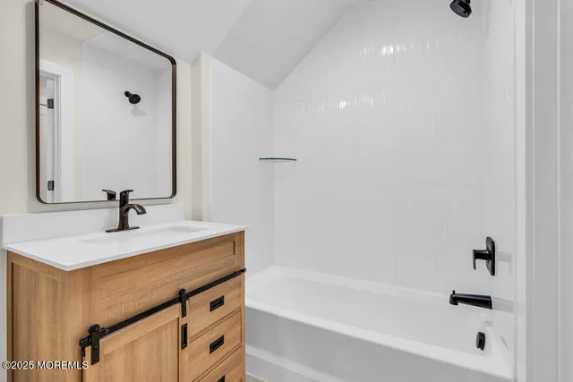 a bathroom with a sink a bathtub and a mirror