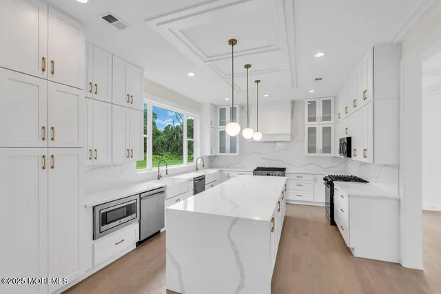 a kitchen with white cabinets and appliances