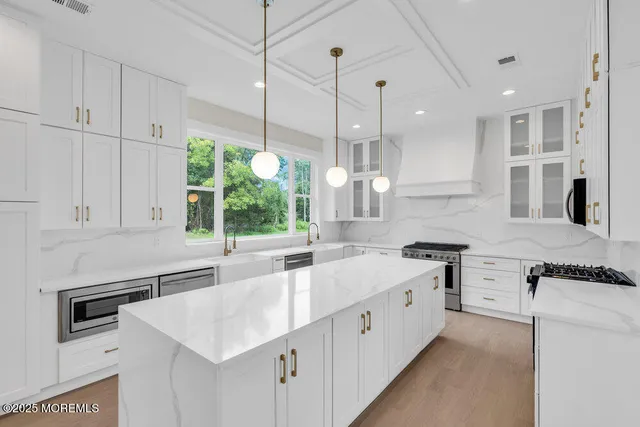 a kitchen with stainless steel appliances granite countertop a sink a stove and a refrigerator