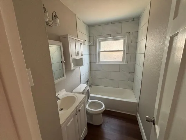 a bathroom with a granite countertop toilet a sink and a bathtub