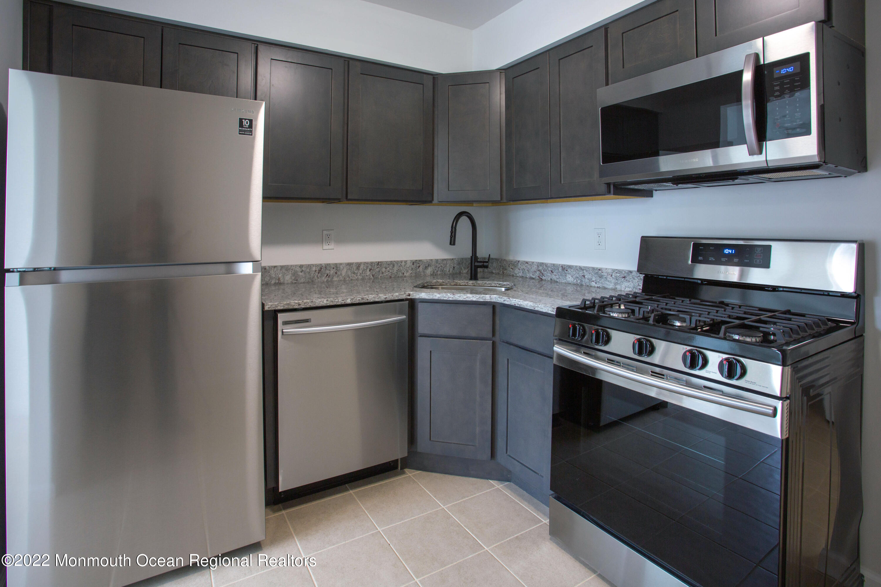 a kitchen with stainless steel appliances a refrigerator stove and microwave