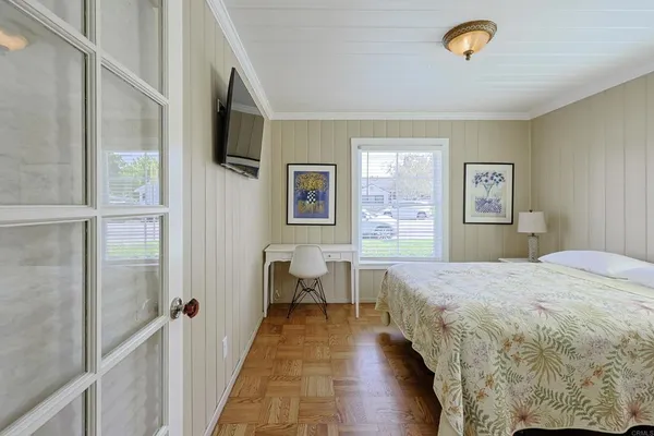 a spacious bedroom with a bed and a flat screen tv