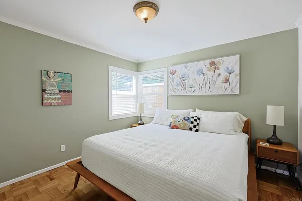 a bedroom with a bed and a lamp on dresser