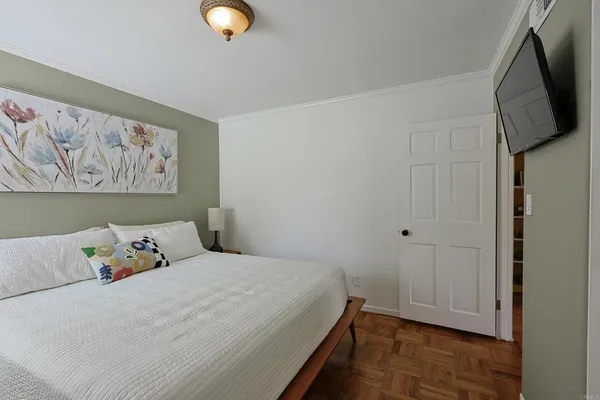 a bedroom with a bed and wooden floor
