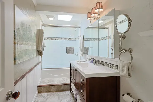 a bathroom with a sink a mirror and a shower