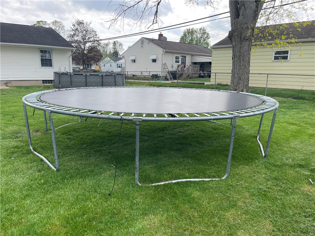 1361 Sussex Road Troy, OH 45373 - Photo 6 of 25 A spacious yard features a trampoline, perfect for outdoor activities and enjoyment.