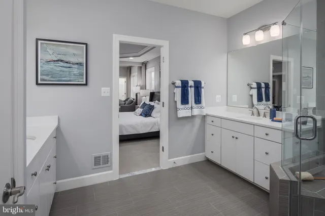 a en suite bathroom with a double vanity sink and a mirror