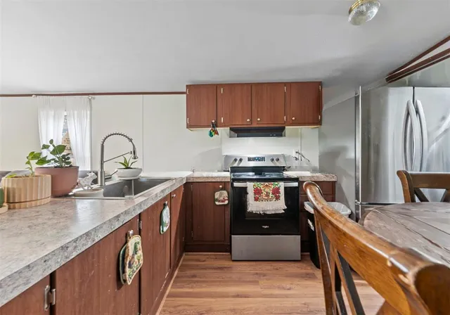 a kitchen with stainless steel appliances granite countertop a sink stove and refrigerator