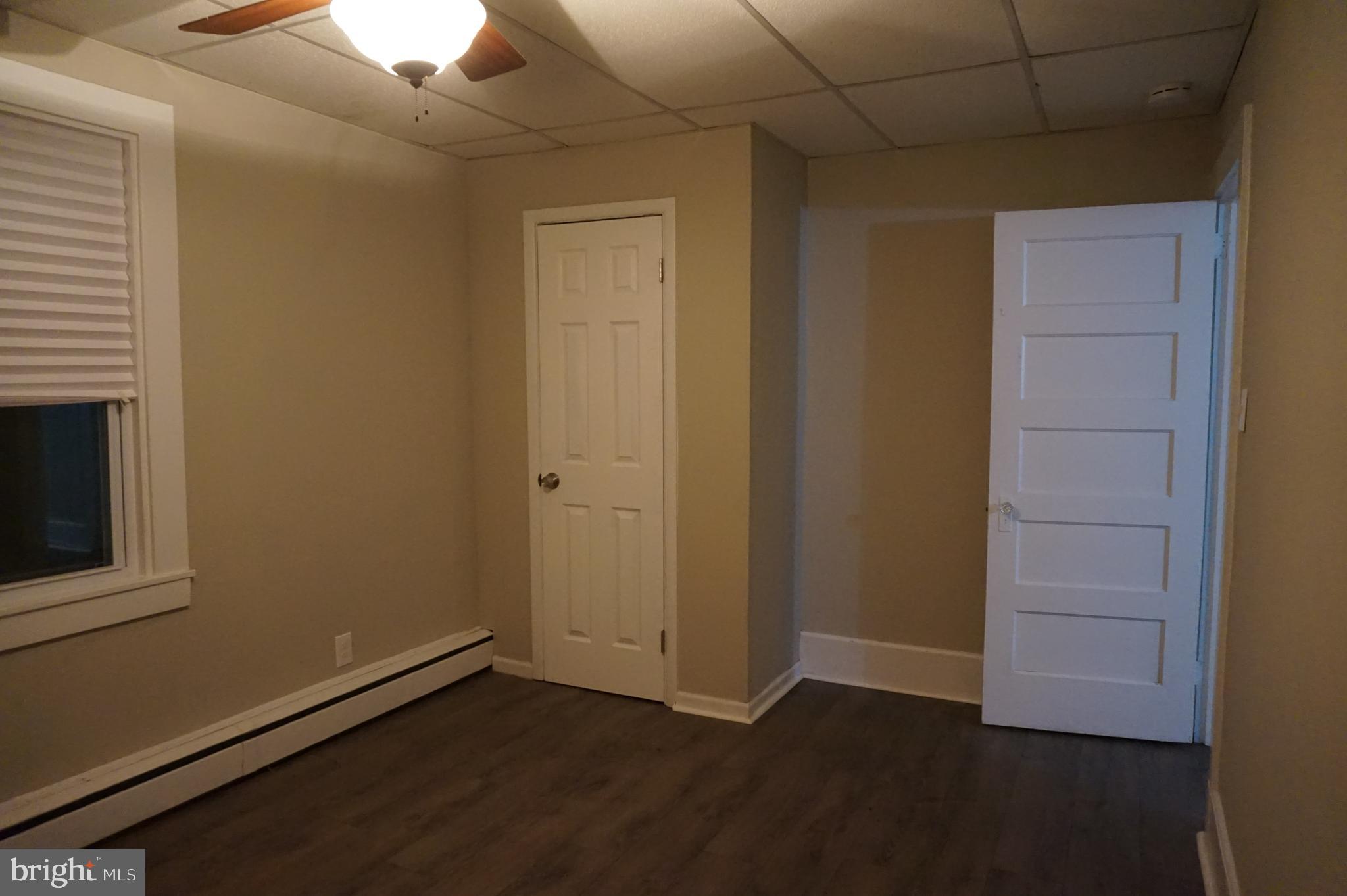 235 Cleveland Street Bristol, PA 19007 - Photo 13 of 18 an empty room with wooden floor and windows