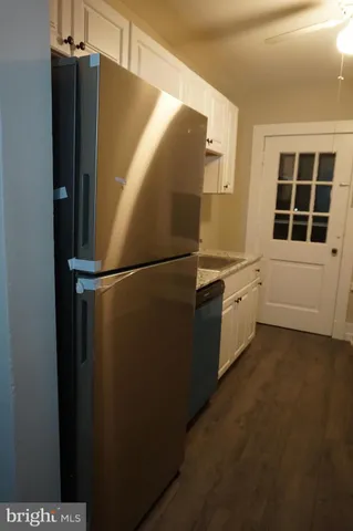 a kitchen with a refrigerator and white cabinets