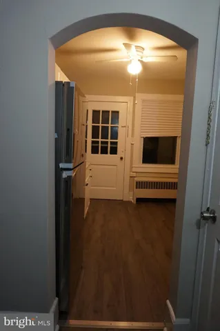 a view of empty room with floor to ceiling window and ceiling fan