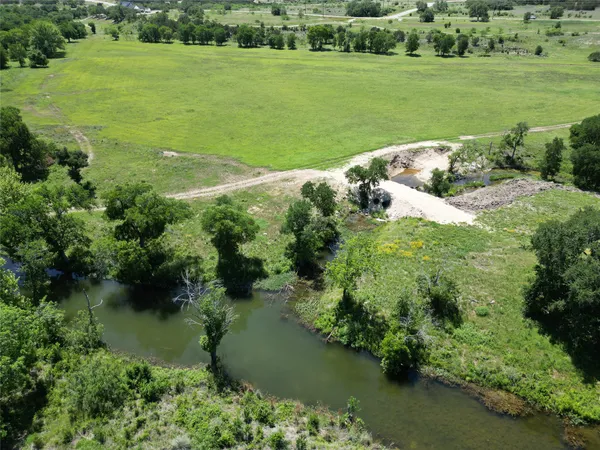 a view of a field with trees in the background
