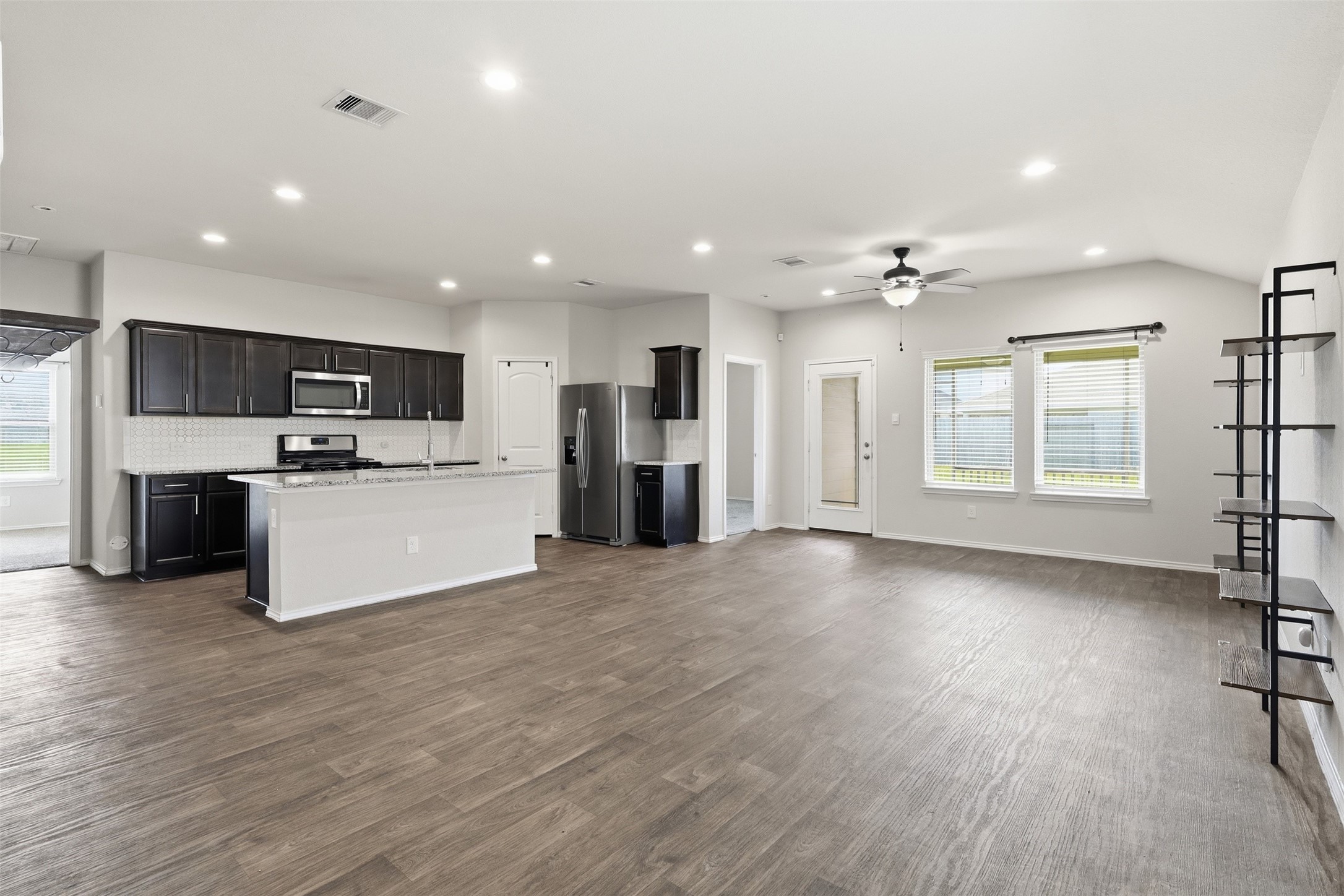 2346 Gold Forsythia Ln Spring Spring, TX 77373 - Photo 14 of 39 Open kitchen overlooks the main living area and features granite countertops, ample cabinetry, stainless steel appliances, and an island with additional bar seating.
