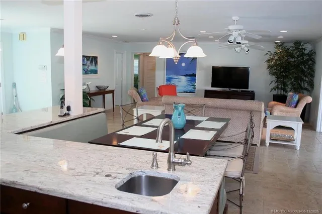 a kitchen with stainless steel appliances granite countertop a sink stove refrigerator and cabinets