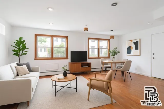 a living room with furniture a window and a flat screen tv