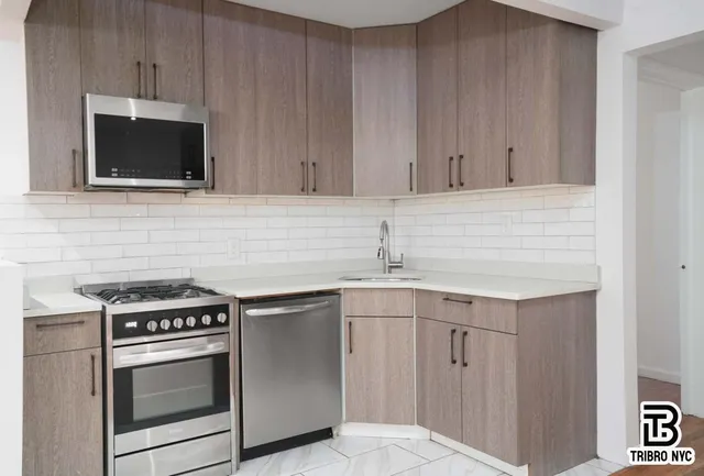 a kitchen with stainless steel appliances granite countertop a sink and a microwave