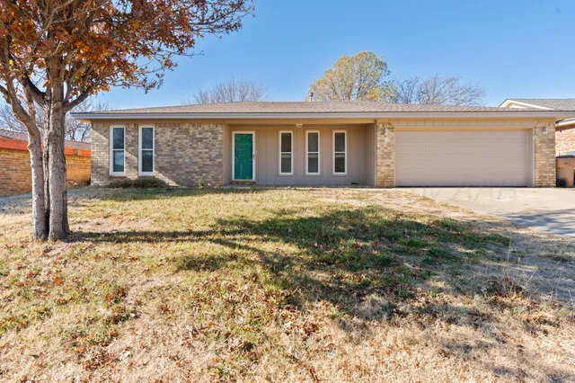 a front view of a house with a garden and yard