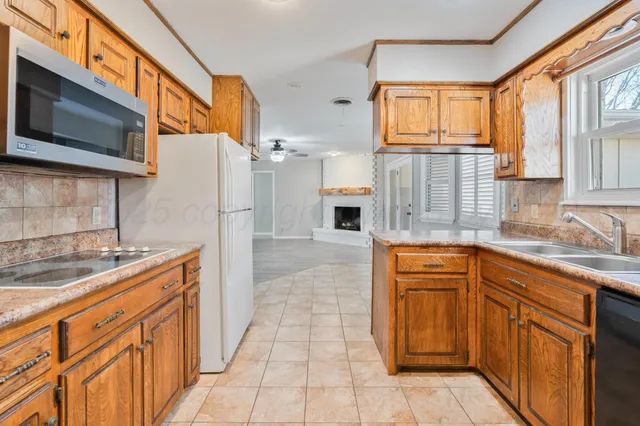 a kitchen with stainless steel appliances granite countertop a refrigerator and a sink