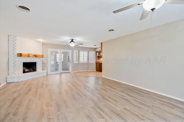 a view of empty room with wooden floor and fireplace