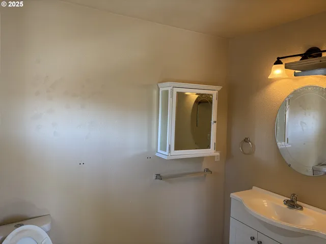 a bathroom with a sink mirror and toilet