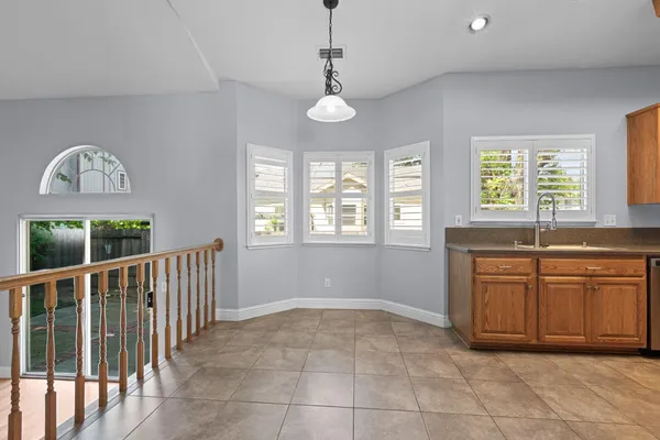 a very nice looking kitchen with granite countertop a stove a sink and a large window