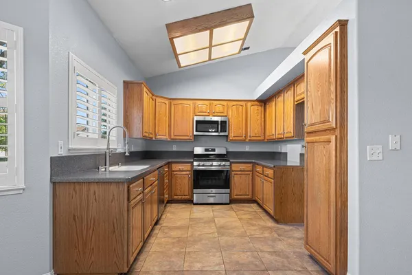 a kitchen with stainless steel appliances granite countertop a sink and a stove