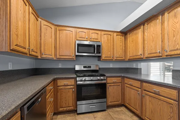 a kitchen with granite countertop a stove top oven microwave and cabinets