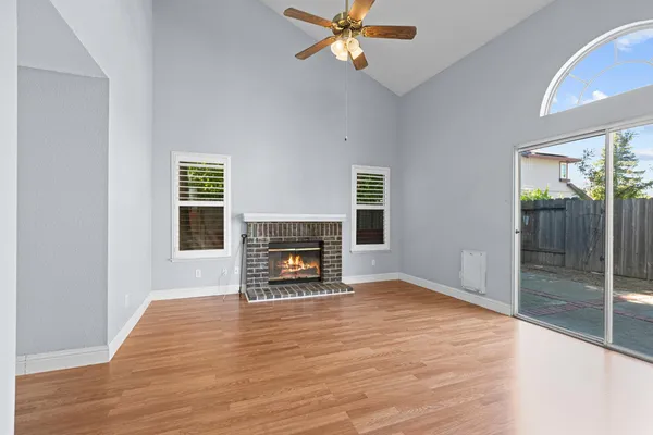 a view of an empty room with a fireplace and a window