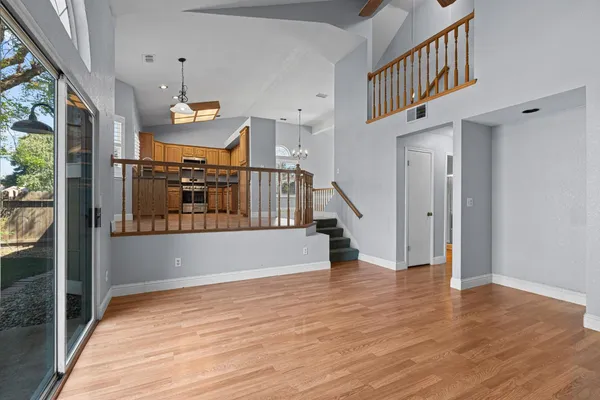 a view of empty room with wooden floor