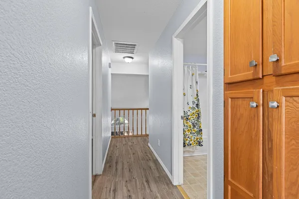 a view of a hallway with wooden floor and entryway