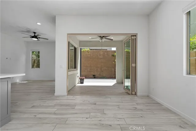 a view of a hallway with wooden floor and a living room
