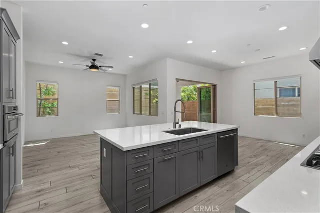 a kitchen with kitchen island granite countertop a sink and dishwasher with wooden floor