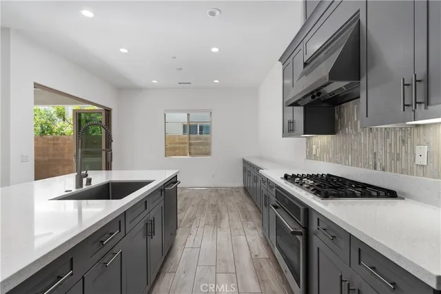 a kitchen with stainless steel appliances granite countertop a sink stove and cabinets