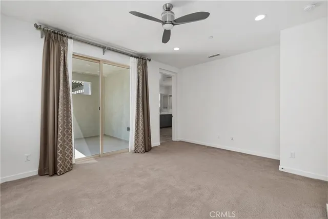 a view of an empty room with a ceiling fan
