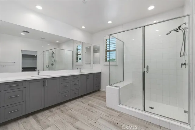 a bathroom with a double vanity sink mirror and shower