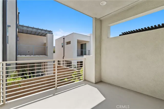 a view of a hallway with two couches and a kitchen view