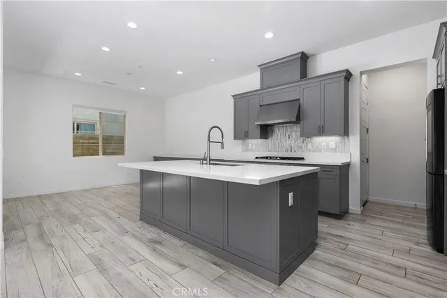 a kitchen with kitchen island granite countertop a sink cabinets and stainless steel appliances