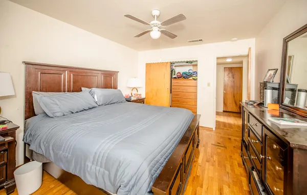 a bedroom with a bed and wooden floor