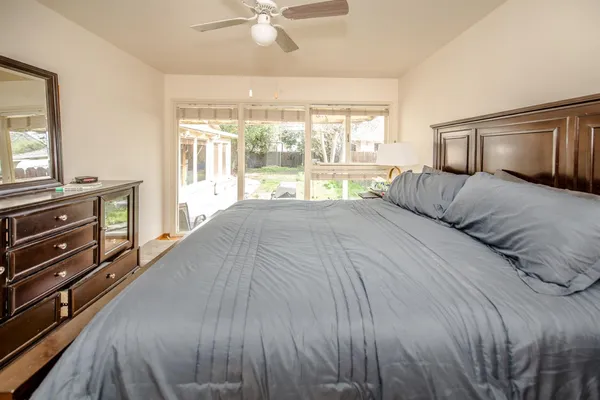 a bedroom with a bed and a large mirror on the dresser