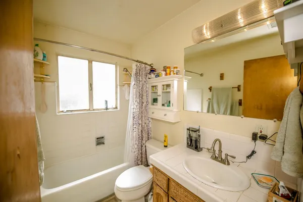 a bathroom with a sink vanity tub and shower