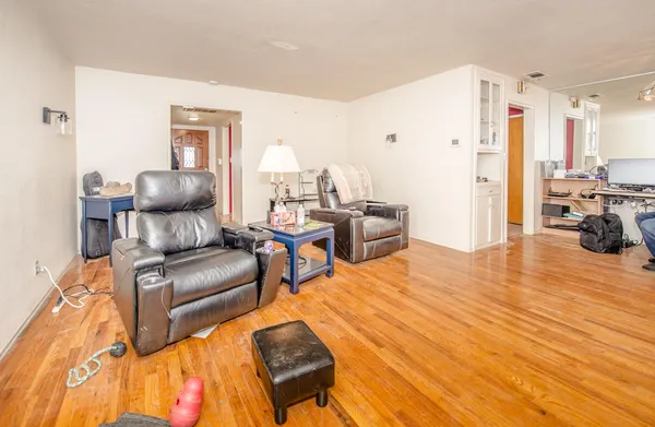 a living room with furniture and a wooden floor