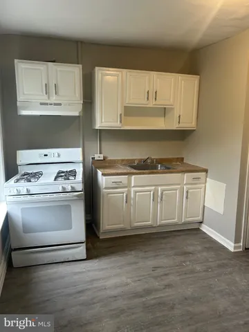 a kitchen with white cabinets and appliances