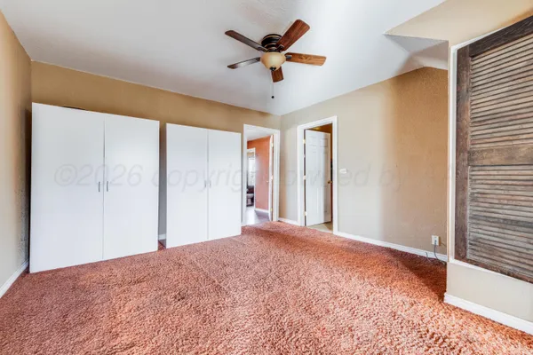 a bed room with a bed and a ceiling fan