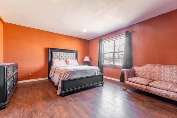 a bedroom with a bed couch and window
