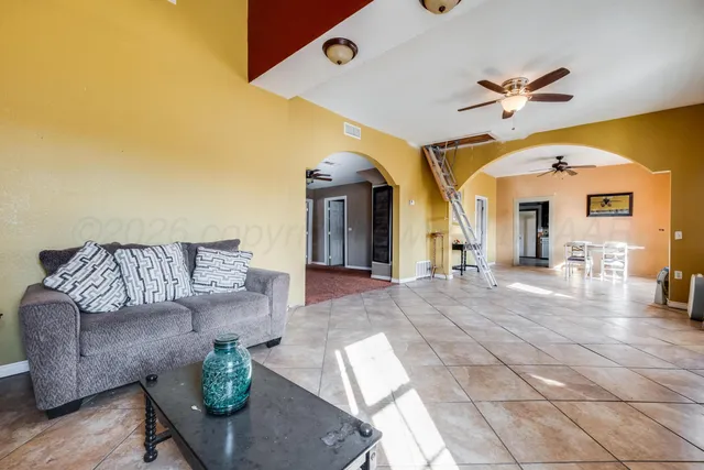 a view of living room kitchen with furniture and a ceiling fan