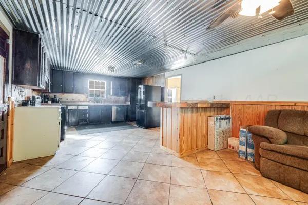a living room with stainless steel appliances kitchen island granite countertop lots of counter space and cabinets