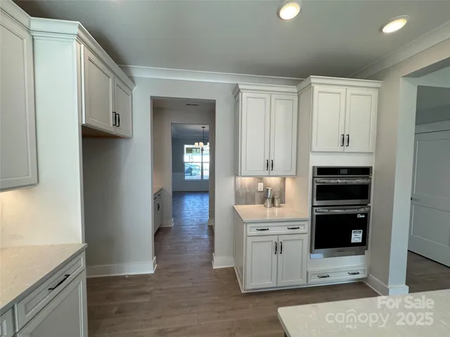 a view of a kitchen with wooden floor and cabinets