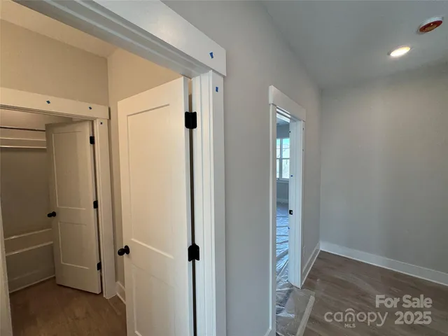 a view of a hallway with wooden floor and closet