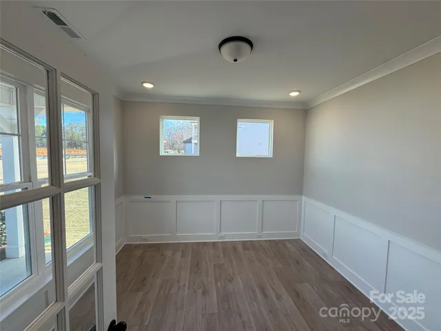 an empty room with wooden floor and fireplace